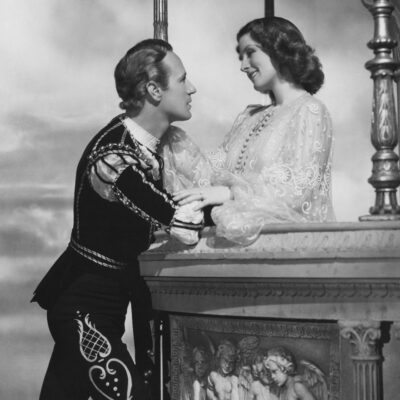 Romeo and Juliet share a tender moment on a balcony
