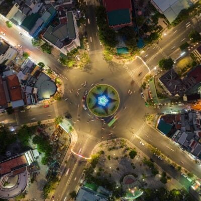 Aerial view of a busy roundabout with illuminated center and surrounding city streets