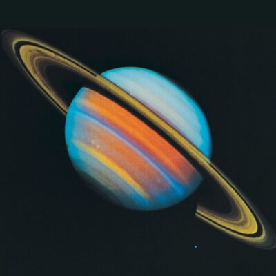 Saturn with colorful bands and tilted rings against a dark background