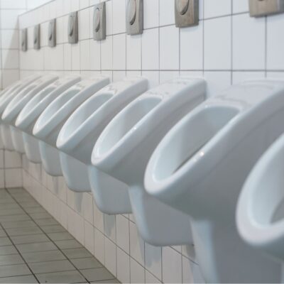 Row of white urinals in a public restroom