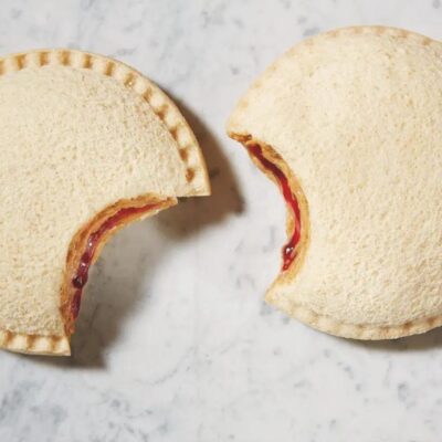 Two partially eaten Smuckers Uncrustables with visible peanut butter and jelly filling