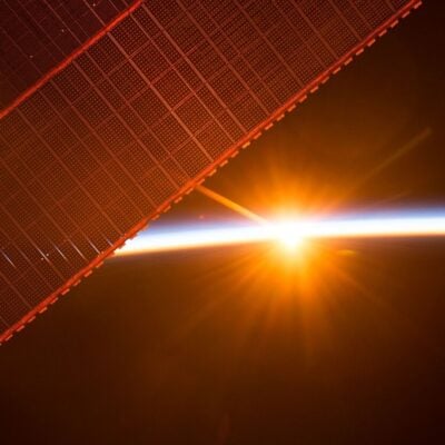Sunrise over Earth seen from the International Space Station with solar panels visible