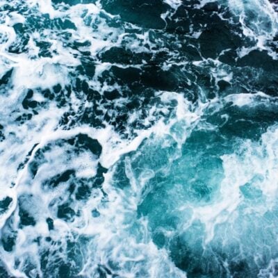 Rough ocean water with foamy white waves and swirling currents