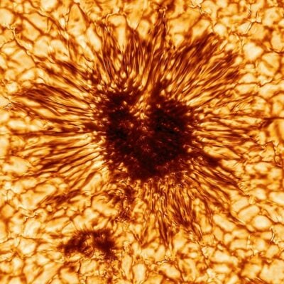 Close-up of a dark sunspot on the Sun's bright, textured surface