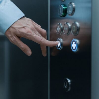 Person pressing down button on elevator control panel