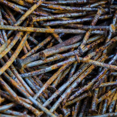 Pile of old, rusty nails with corroded surfaces