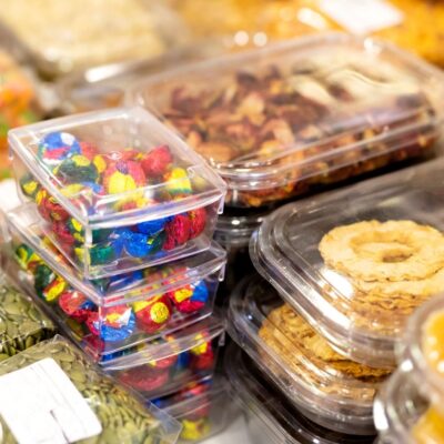 Various sealed plastic food containers filled with snacks and dried fruits