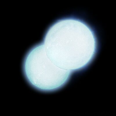 Two bright stars closely orbiting each other in space