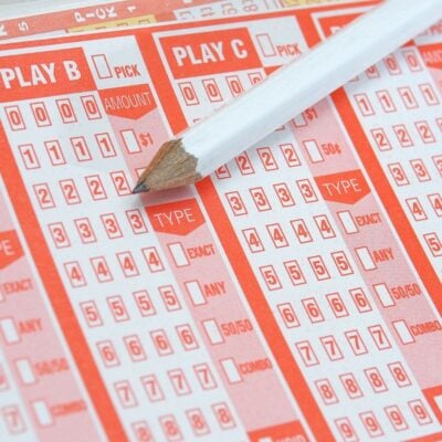 Close-up of lottery tickets with a white pencil placed on top