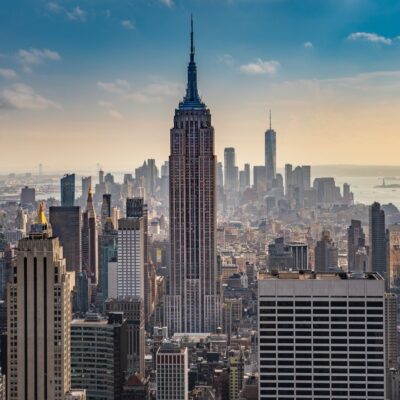 Empire State Building towering over midtown Manhattan skyline at sunset