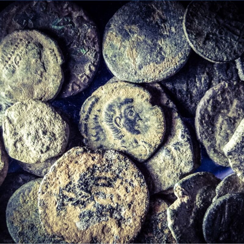 Ancient Lydian coins with engraved human profiles and worn surfaces