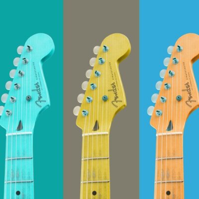 Three Fender Stratocaster guitar heads in teal, yellow, and orange against colorful backgrounds
