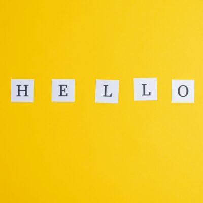 The word HELLO spelled out on white cards against a yellow background