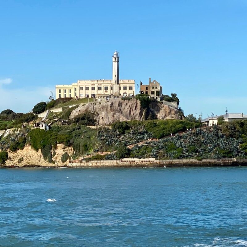 Alcatraz prison building atop rocky island surrounded by cold ocean waters