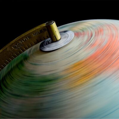 Blurry spinning globe with measurement arm marked in statute miles