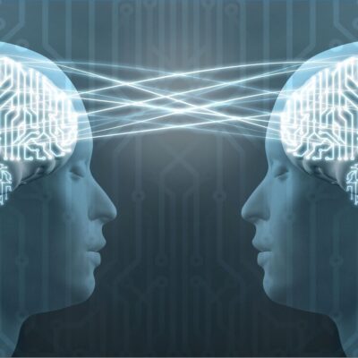 Two human profiles with glowing brains connected by light beams