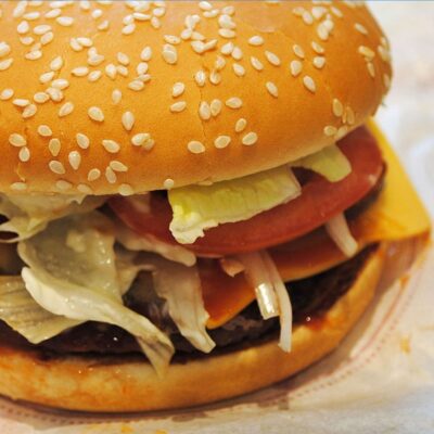 Big Mac with tomato, lettuce, and cheese oozing out