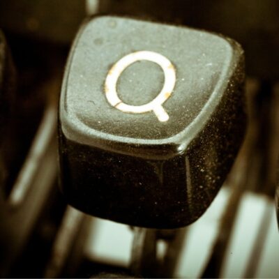 Close-up of a dusty black keyboard key with the letter Q