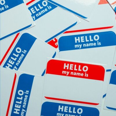 Blue and red 'Hello my name is' name badges scattered