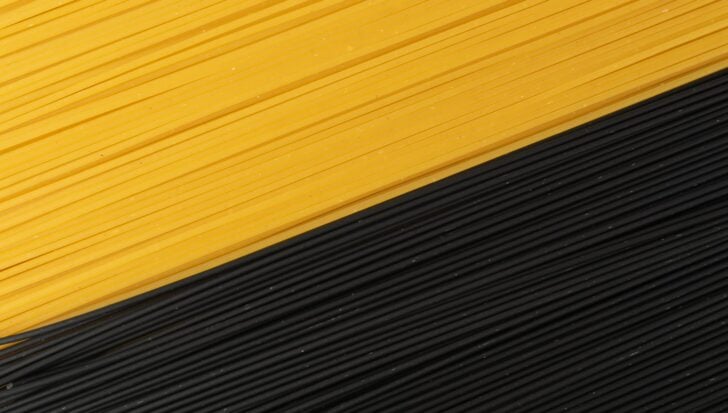 Yellow and black spaghetti arranged in parallel lines