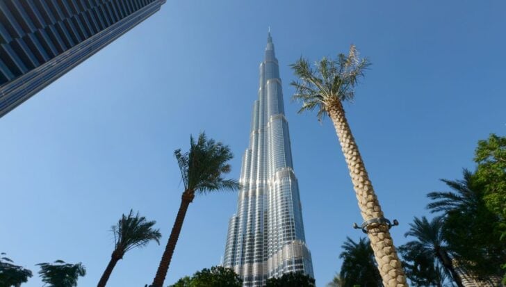 View of the Burj Khalifa with surrounding palm trees and a clear blue sky