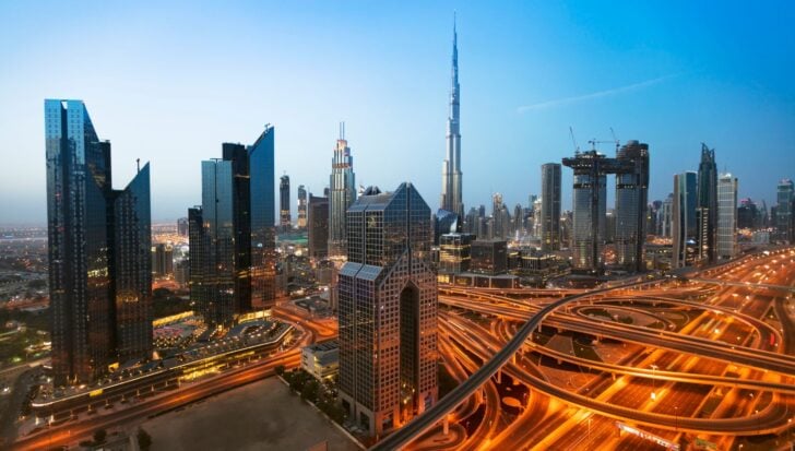 A cityscape of Dubai featuring the Burj Khalifa towering over other skyscrapers with intricate road networks in the foreground